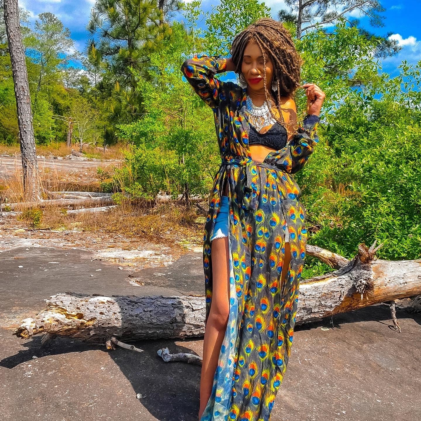 Soulhemian founder Trini wearing a colorful boho maxi dress and statement jewelry